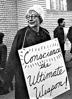 Jane Jacobs in 1962 carrying a protest sign that reads 'Conscience: the ultimate weapon!'