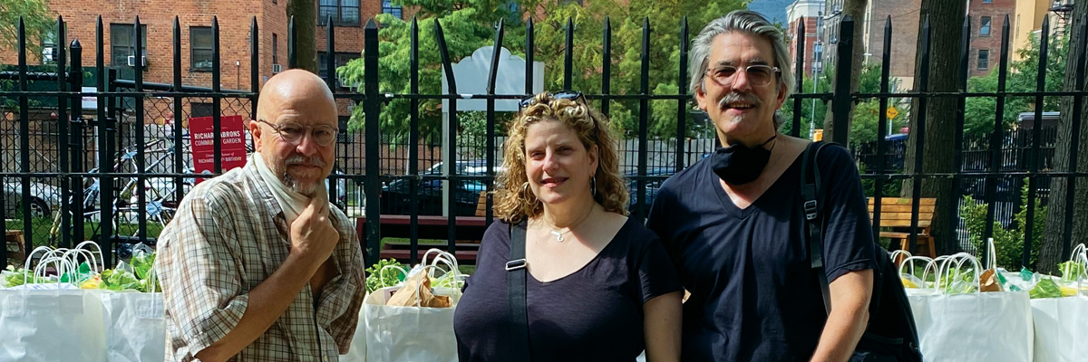 Peculiar Works' founders Ralph Lewis, Catherine Porter, and Barry Rowell pose in front of sacs of food that they delivered to Lower East Side residents for the Henry Street Settlement Food Pantry in 2021.
